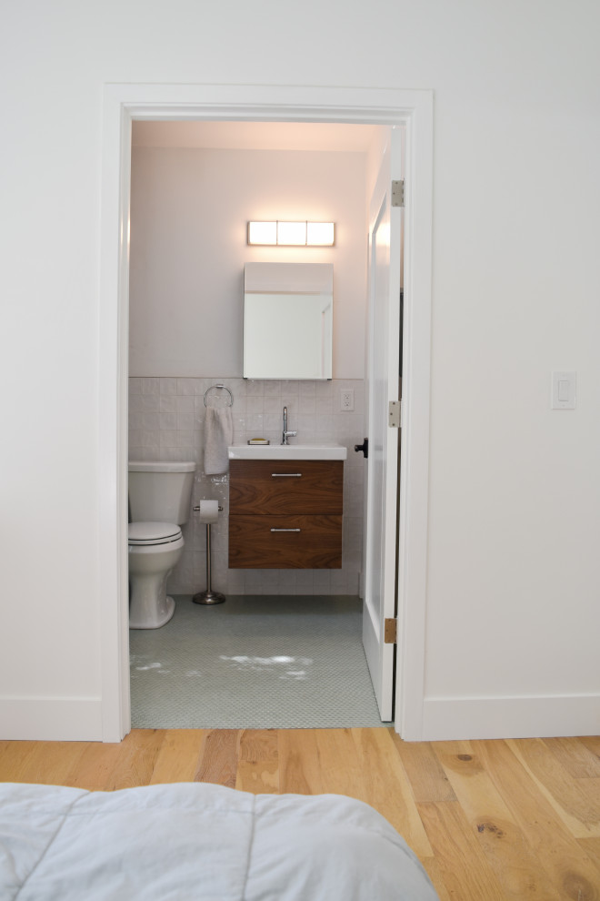 Cette photo montre une salle de bain chic de taille moyenne avec un placard à porte plane, des portes de placard marrons, WC séparés, un carrelage blanc, des carreaux de béton, un mur blanc, un sol en carrelage de porcelaine, un lavabo posé, un plan de toilette en granite, un sol gris, aucune cabine, un plan de toilette blanc, meuble simple vasque, une niche et meuble-lavabo encastré.
