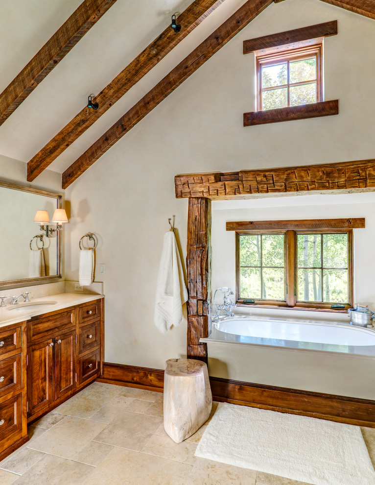 Idéer för stora rustika en-suite badrum, med luckor med infälld panel, skåp i mellenmörkt trä, ett badkar i en alkov, beige väggar, klinkergolv i porslin och ett undermonterad handfat
