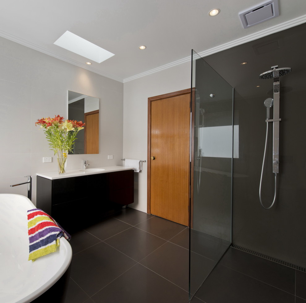 Inspiration för mellanstora moderna badrum, med släta luckor, svarta skåp, ett fristående badkar, en öppen dusch, en vägghängd toalettstol, flerfärgad kakel, porslinskakel, vita väggar, klinkergolv i porslin, ett integrerad handfat, bänkskiva i akrylsten, grått golv och med dusch som är öppen