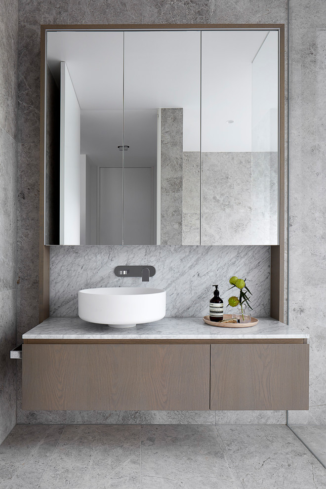 Exemple d'une grande salle de bain tendance en bois brun avec un placard en trompe-l'oeil, un carrelage gris, du carrelage en pierre calcaire, un mur blanc, un sol en calcaire, une vasque, un plan de toilette en marbre, un sol gris et un plan de toilette gris.