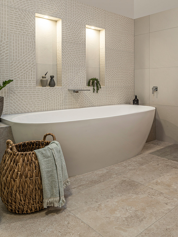 Photo of a large contemporary family bathroom in Melbourne with flat-panel cabinets, medium wood cabinets, a freestanding bath, a built-in shower, a one-piece toilet, white tiles, porcelain tiles, white walls, porcelain flooring, an integrated sink, solid surface worktops, beige floors, a hinged door and white worktops.