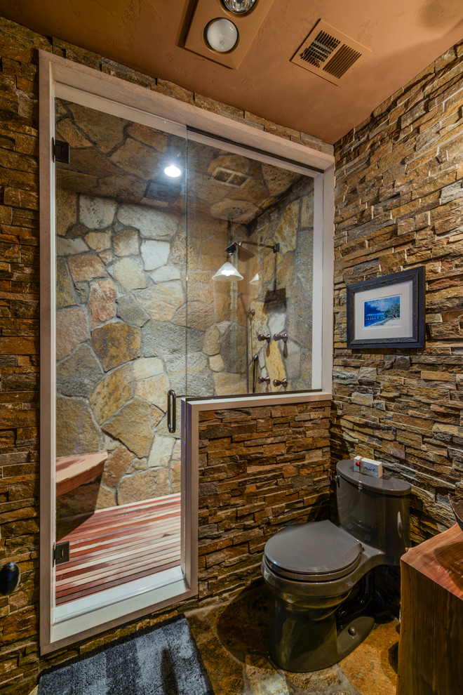 Inspiration for a rustic 3/4 multicolored tile and stone tile slate floor alcove shower remodel in Minneapolis with a two-piece toilet, dark wood cabinets, a vessel sink, wood countertops and brown countertops