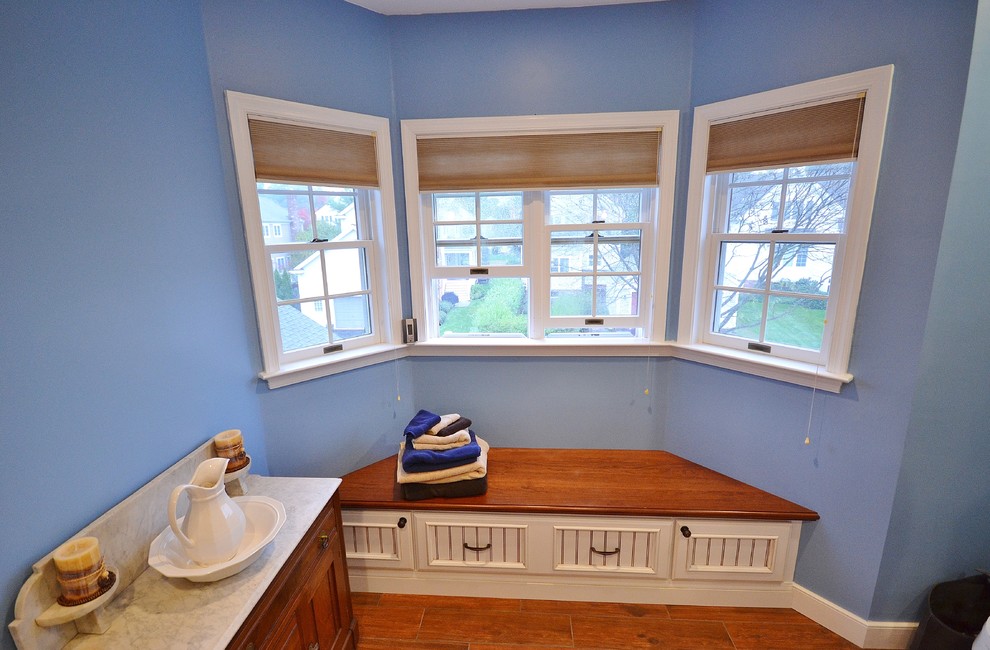 Example of a beach style master blue tile and glass tile porcelain tile alcove shower design in Philadelphia with an undermount sink, recessed-panel cabinets, white cabinets, wood countertops, a two-piece toilet and blue walls
