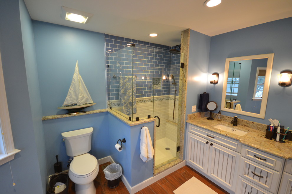 Foto di una stanza da bagno padronale stile marino con lavabo sottopiano, ante con riquadro incassato, ante bianche, top in granito, doccia alcova, WC a due pezzi, piastrelle blu, piastrelle di vetro, pareti blu e pavimento in gres porcellanato