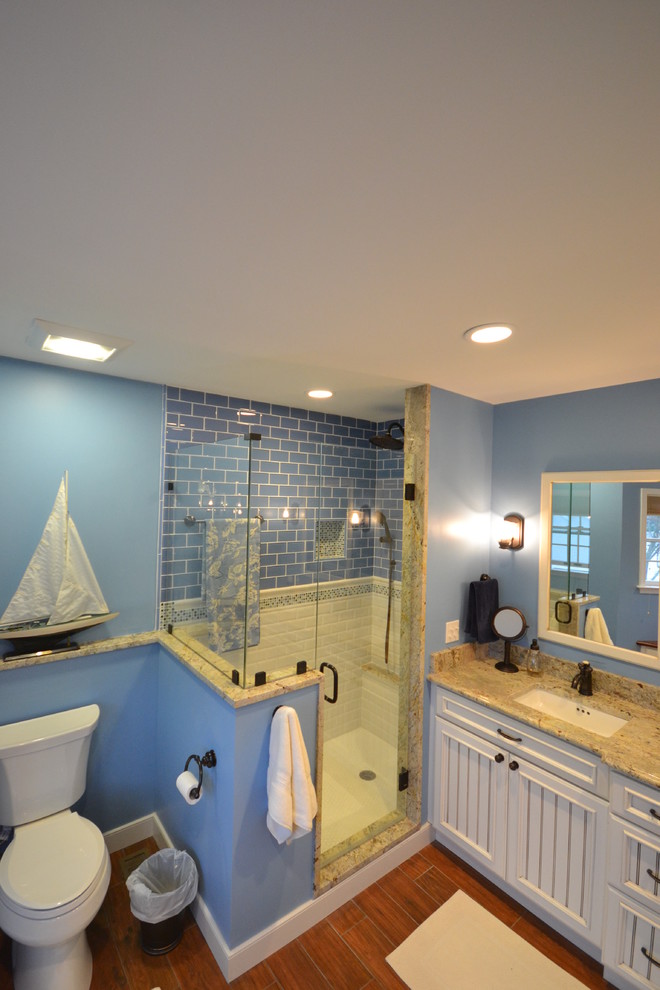 Idee per una stanza da bagno padronale costiera con lavabo sottopiano, ante con riquadro incassato, ante bianche, top in granito, doccia alcova, WC a due pezzi, piastrelle blu, piastrelle di vetro, pareti blu e pavimento in gres porcellanato