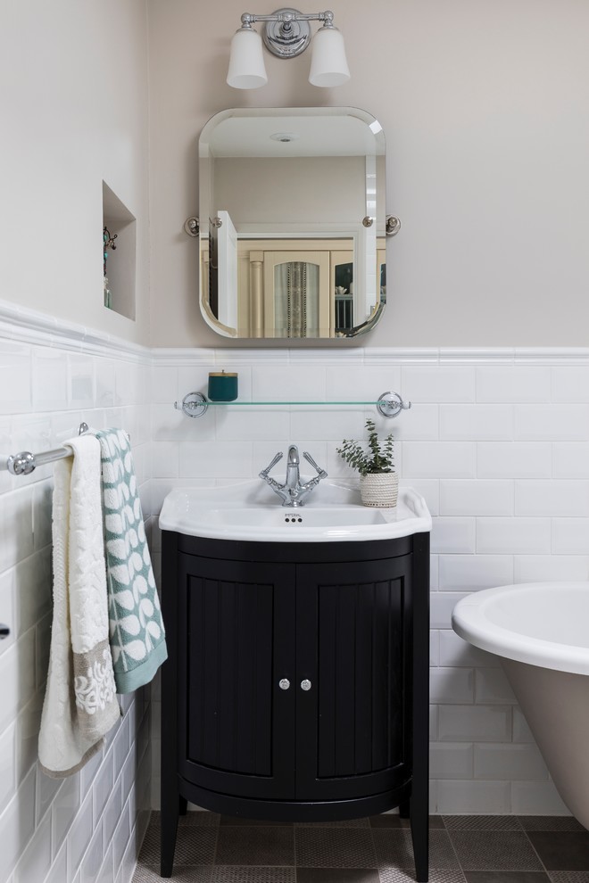 На фото: главная ванная комната в классическом стиле с отдельно стоящей ванной, угловым душем, полом из керамогранита, фасадами в стиле шейкер, черными фасадами, бежевыми стенами и накладной раковиной с