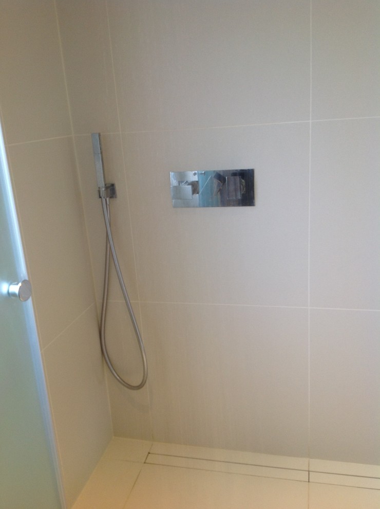 Imagen de cuarto de baño contemporáneo pequeño con ducha abierta, sanitario de pared, baldosas y/o azulejos de porcelana, suelo de baldosas de porcelana, aseo y ducha, lavabo integrado y encimera de cuarcita