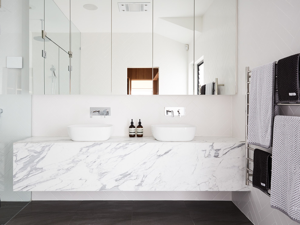 Exemple d'une salle de bain tendance avec des portes de placard blanches, un carrelage blanc, un mur blanc et une vasque.