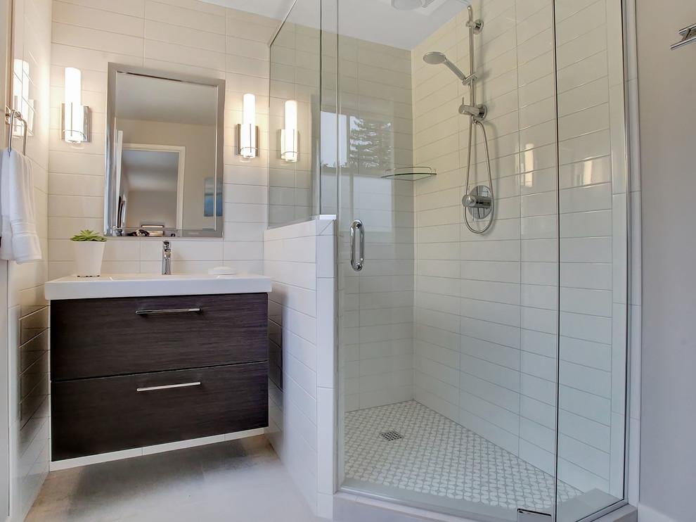 Small trendy master white tile and ceramic tile porcelain tile and gray floor corner shower photo in Portland with flat-panel cabinets, brown cabinets, a two-piece toilet, blue walls, an integrated sink, solid surface countertops, a hinged shower door and white countertops