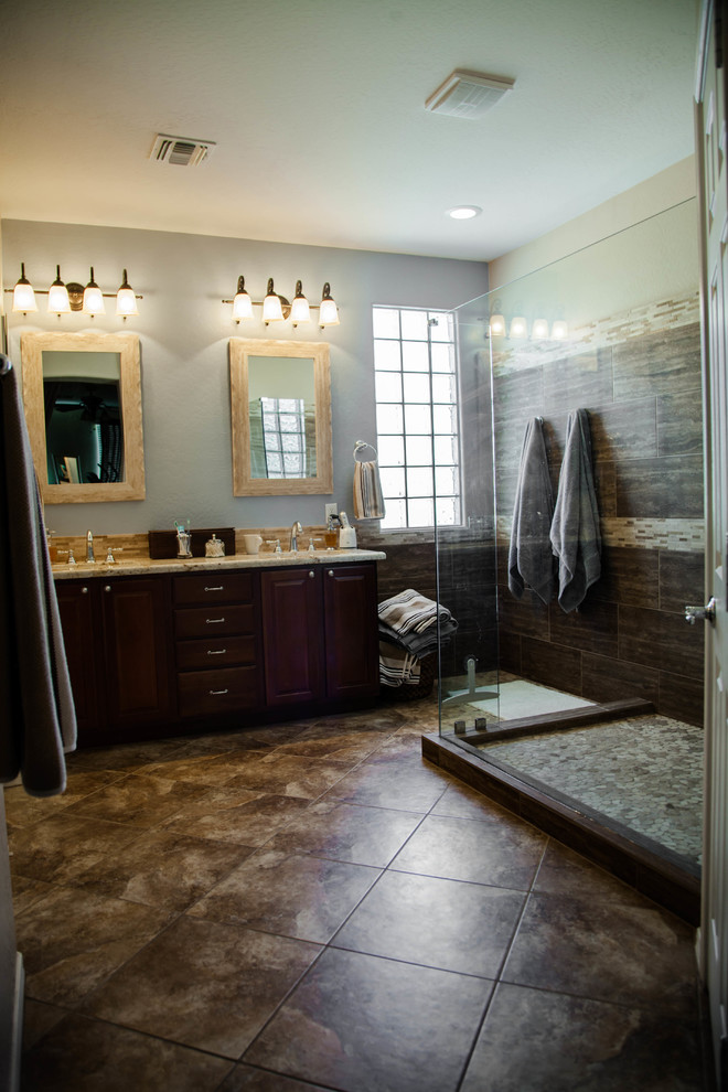 Inspiration pour une salle de bain traditionnelle en bois foncé de taille moyenne avec un placard avec porte à panneau surélevé, une douche d'angle, un mur bleu, un sol en carrelage de céramique, un lavabo encastré et un plan de toilette en granite.