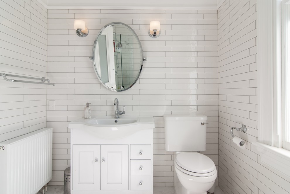 Klassisches Duschbad mit profilierten Schrankfronten, weißen Schränken, Eckdusche, weißer Wandfarbe, Einbauwaschbecken, weißer Waschtischplatte und Wandtoilette mit Spülkasten in Auckland