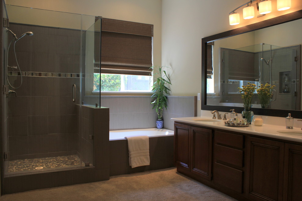 Idéer för stora funkis en-suite badrum, med luckor med infälld panel, skåp i mellenmörkt trä, ett hörnbadkar, en hörndusch, grå kakel, porslinskakel, beige väggar, ett undermonterad handfat och bänkskiva i akrylsten