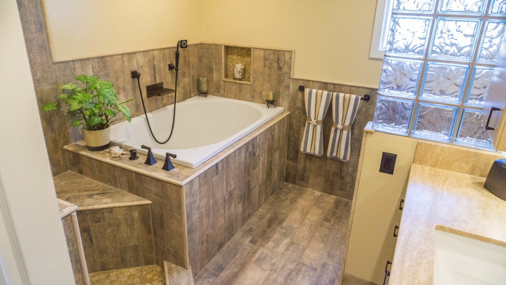 На фото: главная ванная комната среднего размера в стиле фьюжн с плоскими фасадами, светлыми деревянными фасадами, накладной ванной, врезной раковиной и мраморной столешницей
