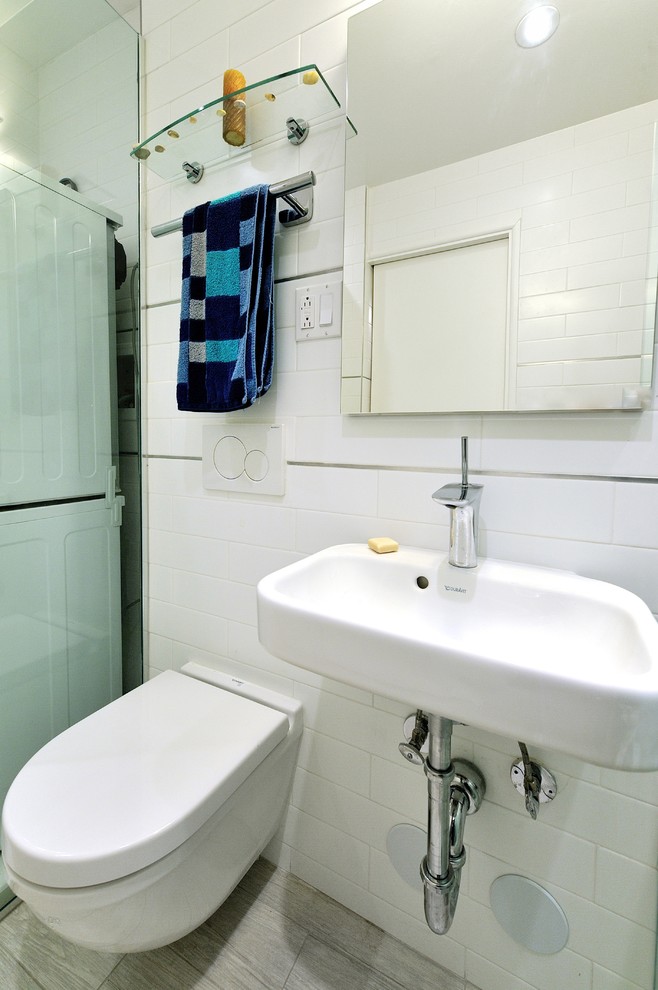 Cette photo montre une salle de bain principale moderne de taille moyenne avec un plan vasque, un plan de toilette en surface solide, une douche d'angle, un carrelage blanc, des carreaux de céramique, un mur blanc et un sol en carrelage de céramique.