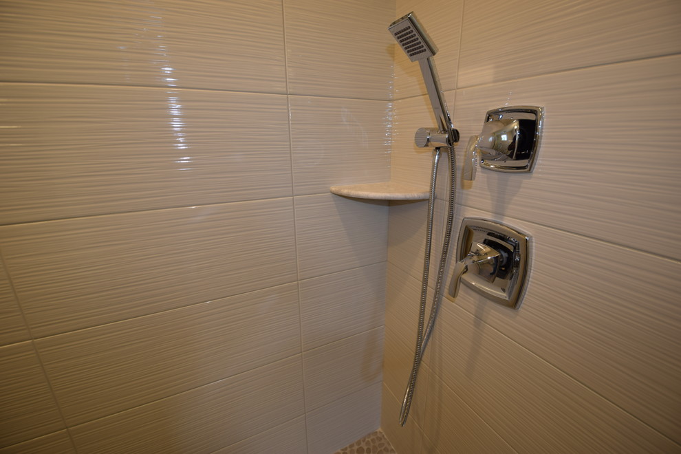 На фото: большая главная ванная комната в морском стиле с фасадами с утопленной филенкой, белыми фасадами, душем в нише, бежевой плиткой, керамогранитной плиткой, серыми стенами, коричневым полом и душем с распашными дверями с