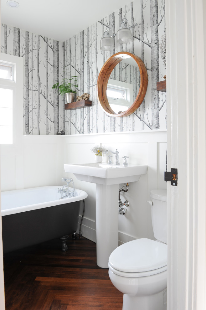 Klassisches Duschbad mit Löwenfuß-Badewanne, Wandtoilette mit Spülkasten, weißer Wandfarbe, dunklem Holzboden, Waschtischkonsole und weißer Waschtischplatte in Vancouver