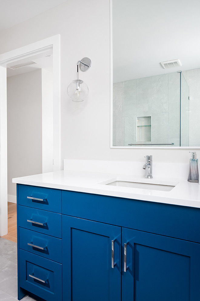 Ispirazione per una stanza da bagno minimalista di medie dimensioni con ante in stile shaker, ante blu, WC monopezzo, piastrelle bianche, pareti bianche, lavabo sottopiano, pavimento bianco e top bianco