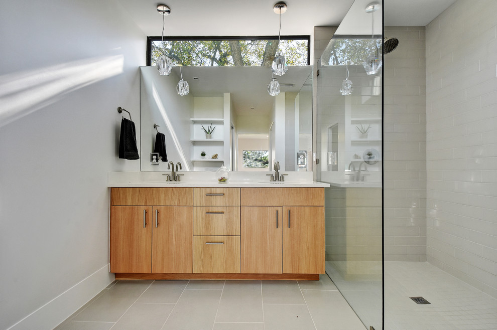 Exempel på ett modernt badrum med dusch, med släta luckor, skåp i mellenmörkt trä, en kantlös dusch, grå kakel, tunnelbanekakel och ett undermonterad handfat