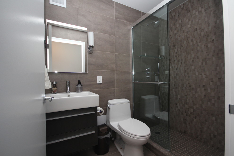 Bild på ett mellanstort funkis badrum med dusch, med grå kakel, möbel-liknande, en dusch i en alkov, en toalettstol med hel cisternkåpa och ett avlångt handfat