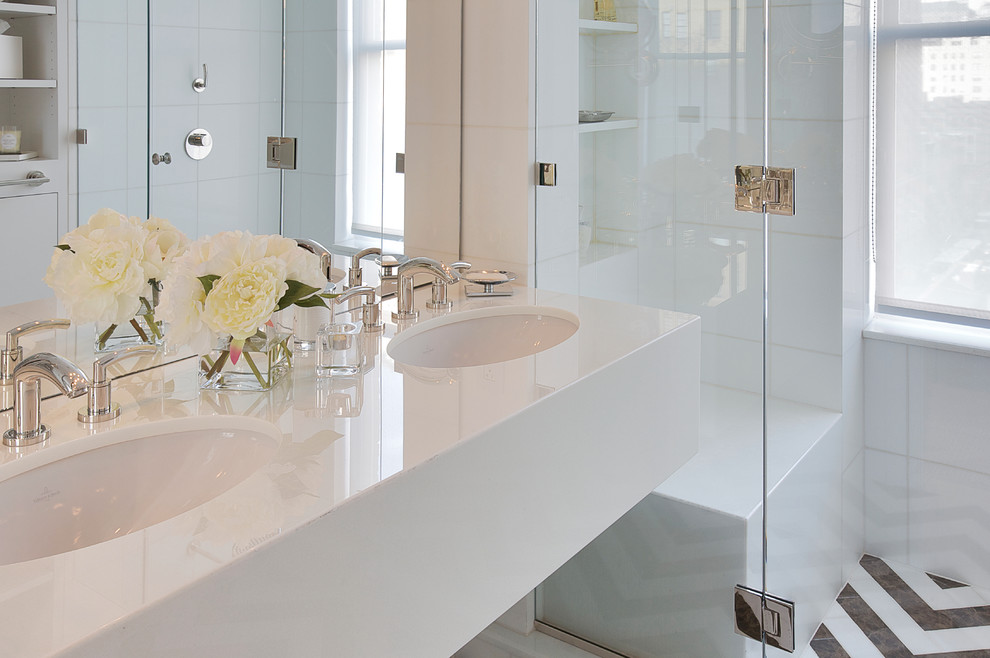 This is an example of a classic bathroom in New York with white tiles, white walls and mosaic tile flooring.