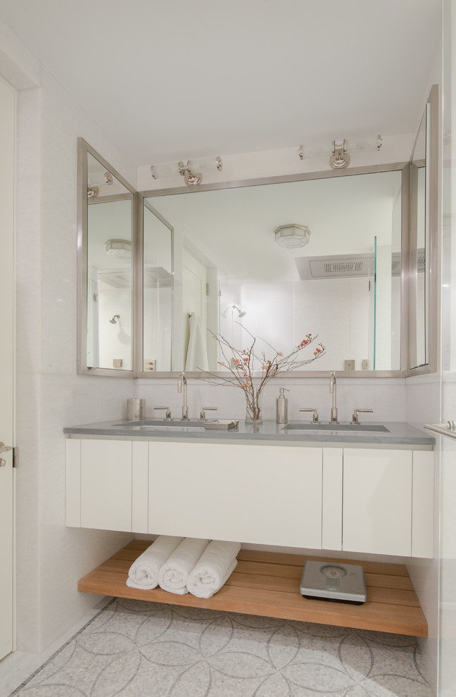Cette photo montre une salle de bain chic avec un placard à porte plane, des portes de placard blanches, un sol en carrelage de terre cuite, un lavabo encastré, un sol blanc et un plan de toilette gris.