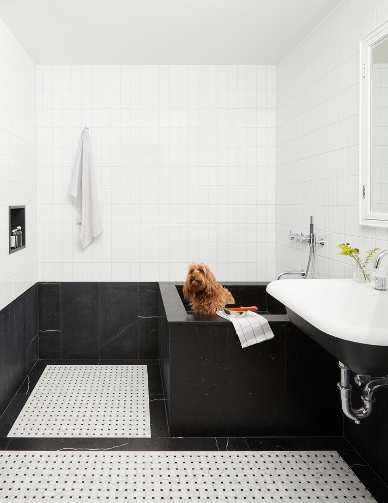 Immagine di una stanza da bagno design con piastrelle nere, pistrelle in bianco e nero, piastrelle bianche, pareti multicolore, lavabo sospeso e pavimento multicolore