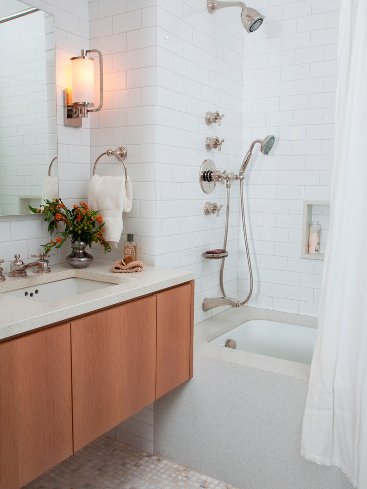 Photo of a small classic bathroom in New York with flat-panel cabinets, medium wood cabinets, solid surface worktops, a submerged bath, a shower/bath combination, white tiles, ceramic tiles, white walls, mosaic tile flooring and a shower curtain.