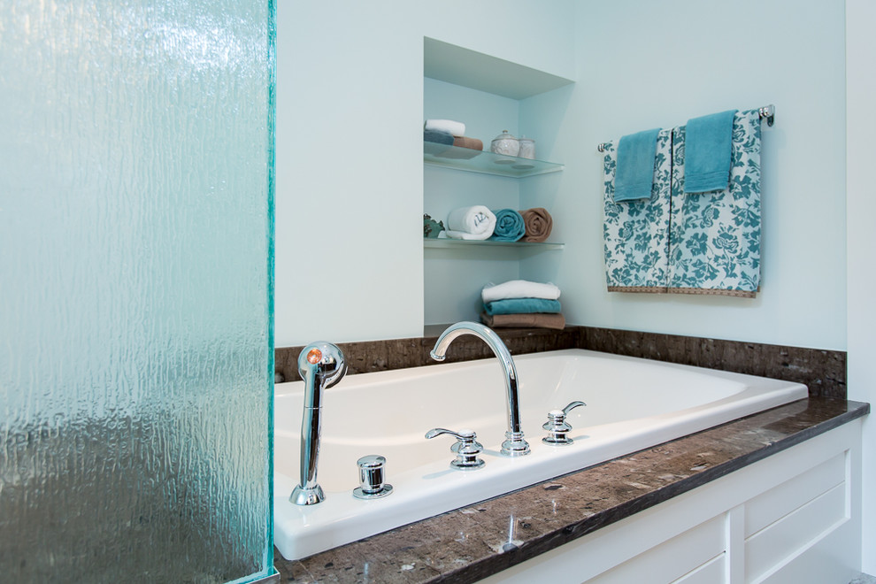 Cette photo montre une douche en alcôve bord de mer en bois foncé avec une vasque, un placard à porte plane, un plan de toilette en granite, un carrelage blanc, des carreaux de céramique, un mur bleu, un sol en carrelage de céramique et une baignoire posée.