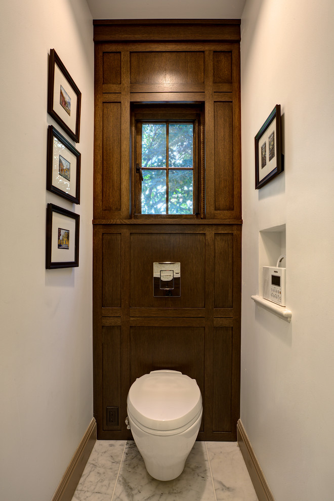 Inspiration for a small traditional cloakroom in San Francisco with shaker cabinets, dark wood cabinets, a wall mounted toilet, white tiles, stone tiles, white walls, marble flooring, a submerged sink, solid surface worktops, white floors, a feature wall and wood walls.