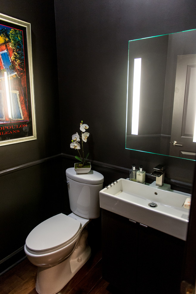 Пример оригинального дизайна: маленькая ванная комната в современном стиле с раковиной с несколькими смесителями, плоскими фасадами, черными фасадами, унитазом-моноблоком, коричневыми стенами и темным паркетным полом для на участке и в саду