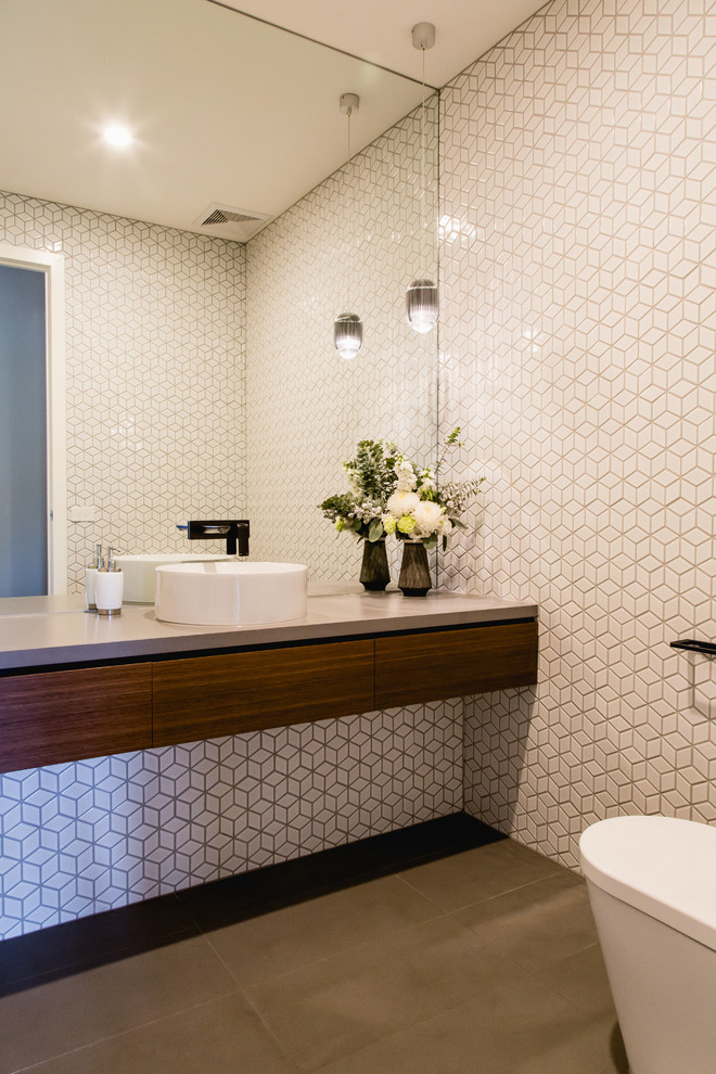Photo of a medium sized contemporary ensuite bathroom in Melbourne with flat-panel cabinets, dark wood cabinets, a walk-in shower, a one-piece toilet, grey tiles, ceramic tiles, white walls, concrete flooring, a built-in sink, concrete worktops, grey floors and grey worktops.