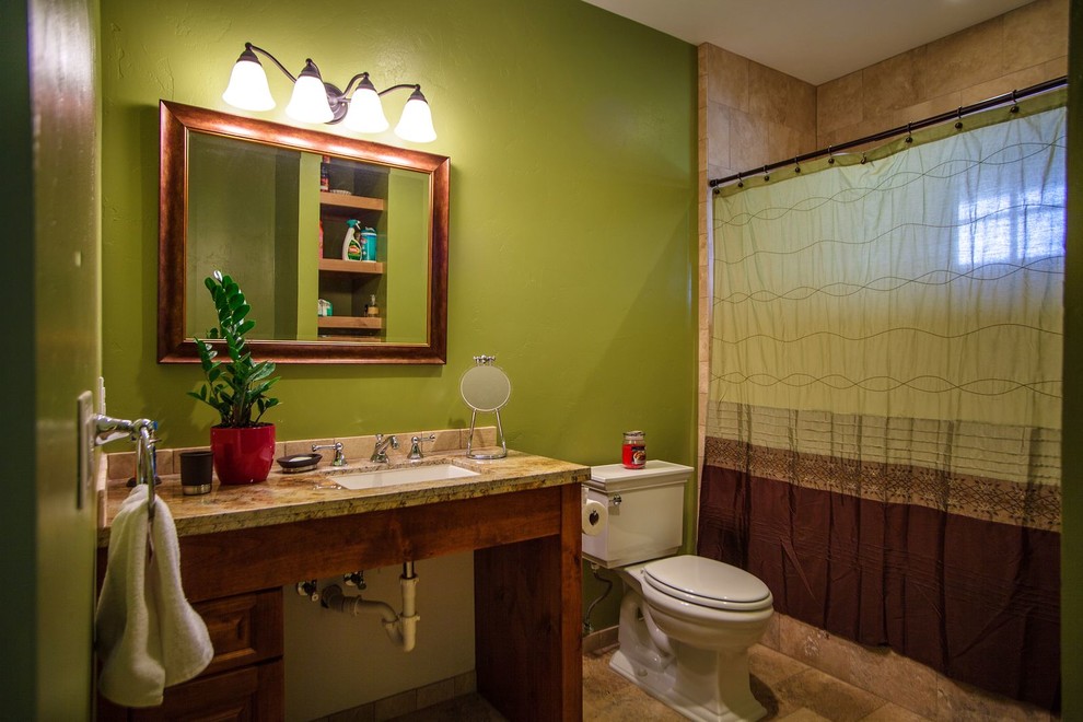Idéer för att renovera ett mellanstort vintage badrum för barn, med luckor med upphöjd panel, skåp i mellenmörkt trä, ett platsbyggt badkar, en toalettstol med separat cisternkåpa, beige kakel, stenkakel, gröna väggar, klinkergolv i porslin, ett undermonterad handfat och granitbänkskiva
