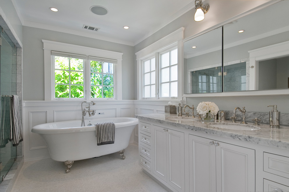 На фото: ванная комната в классическом стиле с фасадами с утопленной филенкой, белыми фасадами, ванной на ножках, серыми стенами, полом из мозаичной плитки, врезной раковиной, белым полом и серой столешницей с