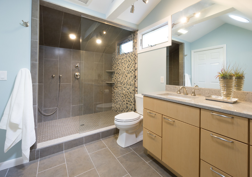 Inredning av ett modernt mellanstort en-suite badrum, med släta luckor, skåp i ljust trä, bänkskiva i kvarts, grå kakel, porslinskakel, en öppen dusch, en toalettstol med separat cisternkåpa, ett undermonterad handfat, blå väggar och klinkergolv i porslin