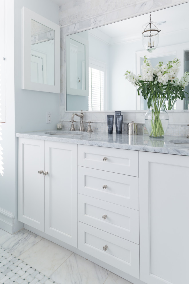 Beach style bathroom photo in New York with an undermount sink, recessed-panel cabinets, white cabinets and white walls