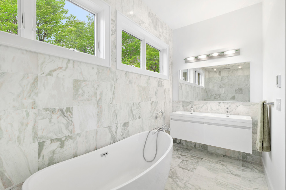 На фото: большая главная ванная комната в стиле модернизм с белыми фасадами, отдельно стоящей ванной, разноцветной плиткой, мраморной плиткой, разноцветными стенами, мраморным полом, разноцветным полом, белой столешницей, плоскими фасадами, монолитной раковиной и столешницей из искусственного кварца