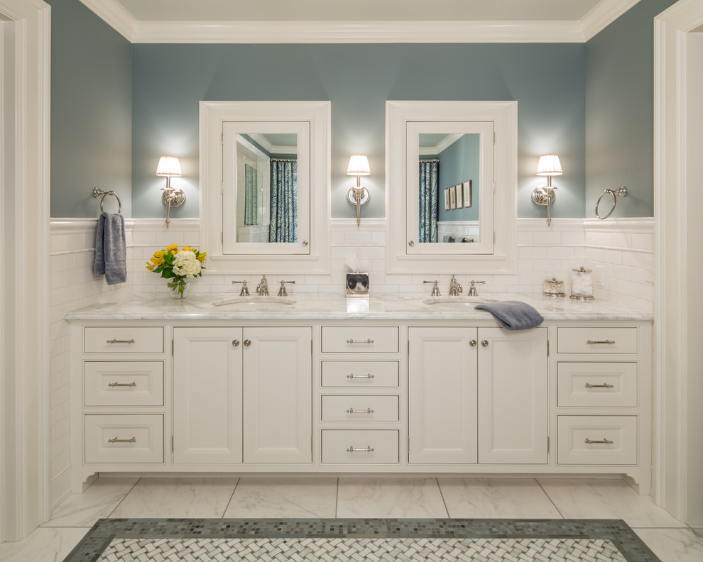 Modelo de cuarto de baño tradicional con armarios con paneles empotrados, puertas de armario blancas, lavabo bajoencimera y espejo con luz