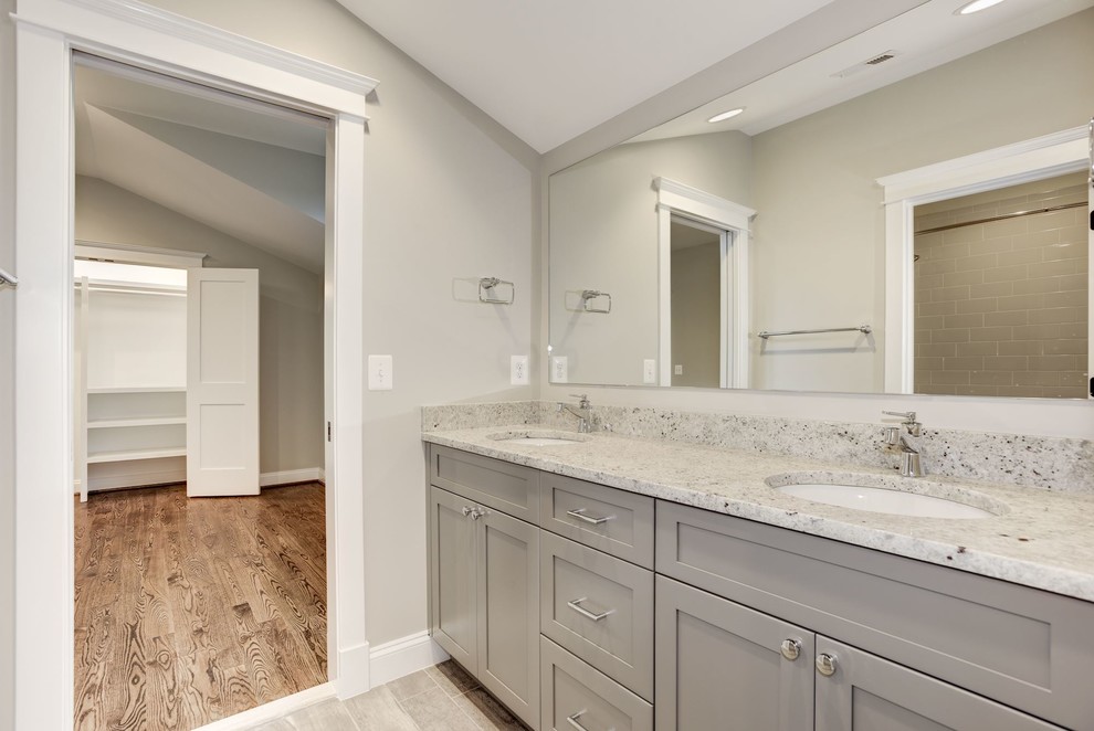 Bathroom - transitional kids' gray tile and ceramic tile ceramic tile and gray floor bathroom idea in DC Metro with shaker cabinets, gray cabinets, a two-piece toilet, gray walls, an undermount sink, solid surface countertops, a hinged shower door and gray countertops