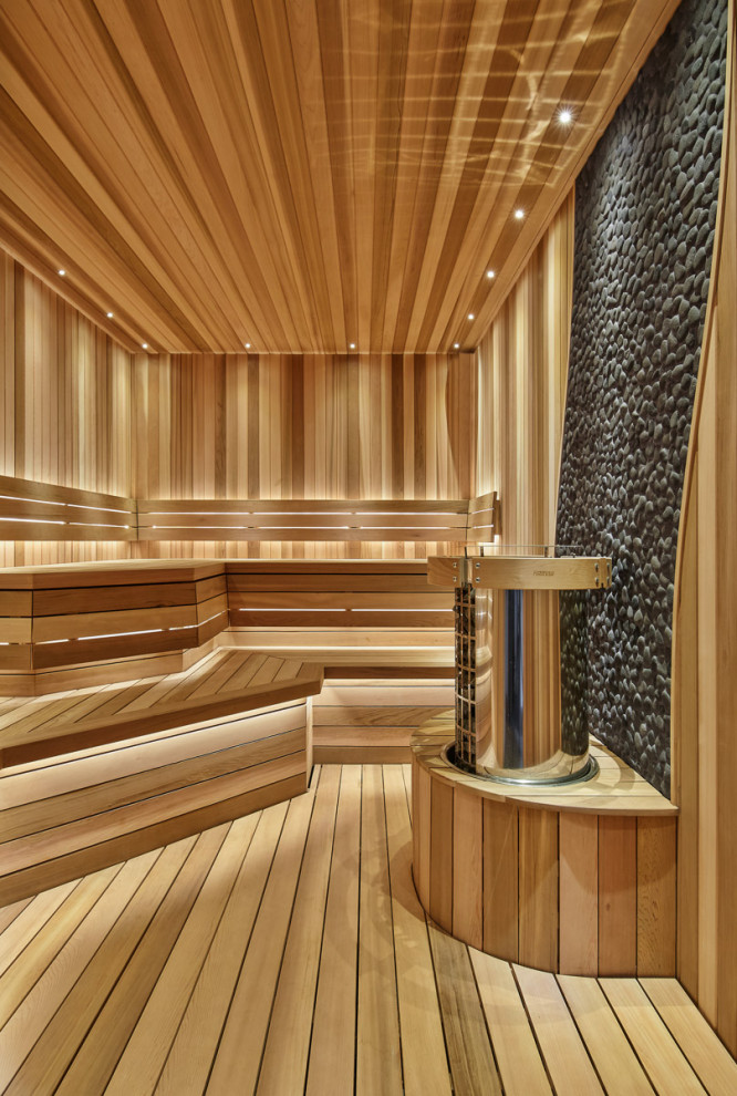 Réalisation d'un grand sauna chalet en bois avec parquet clair, un sol beige, un plafond en bois, un carrelage gris et une plaque de galets.
