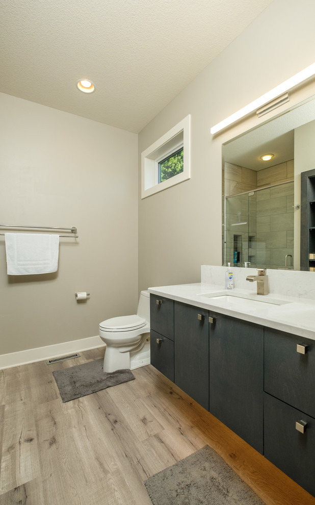 Bild på ett mellanstort funkis badrum, med släta luckor, grå skåp, en dusch i en alkov, grå väggar, ett undermonterad handfat, bänkskiva i kvarts och dusch med gångjärnsdörr