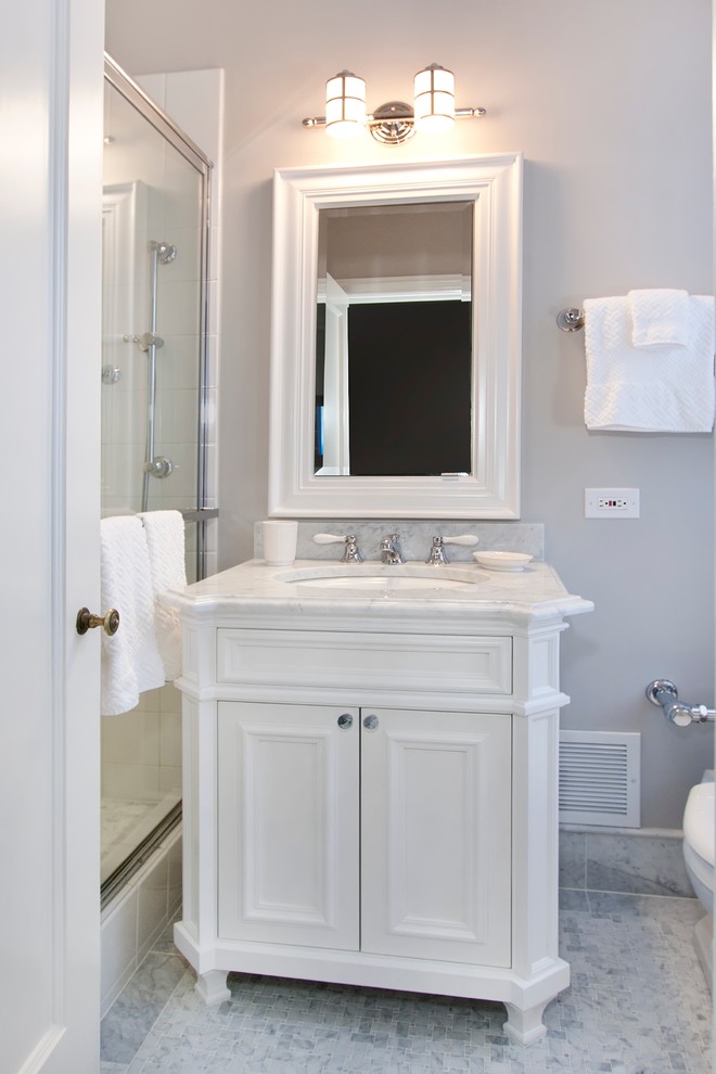 Example of a small classic kids' white tile and stone tile marble floor corner shower design in Chicago with an undermount sink, recessed-panel cabinets, white cabinets, marble countertops, a one-piece toilet and gray walls