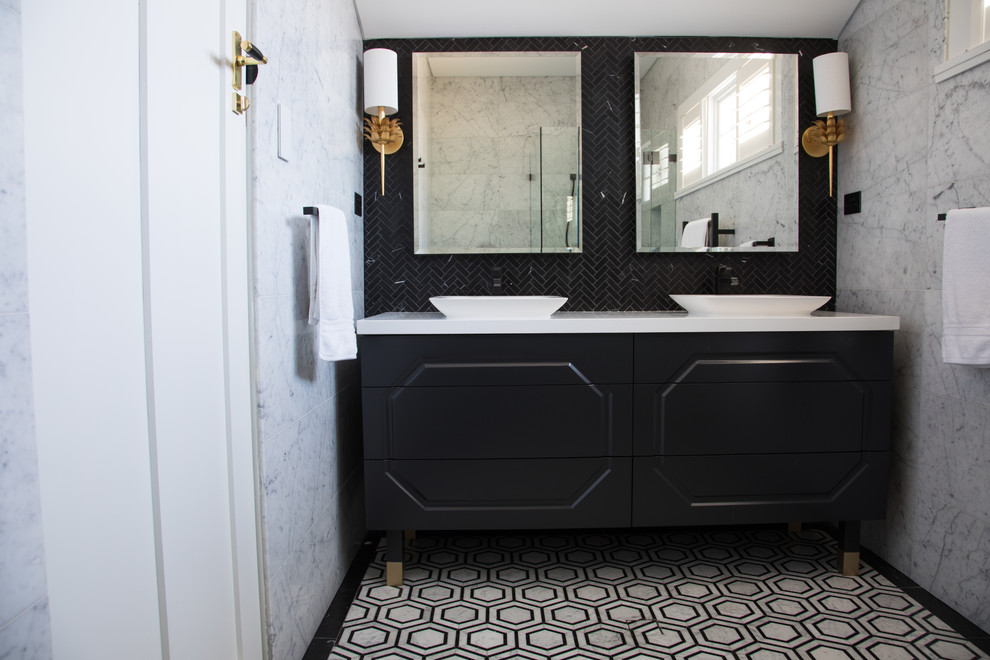 This is an example of a medium sized contemporary ensuite bathroom in Sydney with freestanding cabinets, black cabinets, a corner shower, a one-piece toilet, grey tiles, marble tiles, white walls, marble flooring, a vessel sink, engineered stone worktops, multi-coloured floors, a hinged door and white worktops.