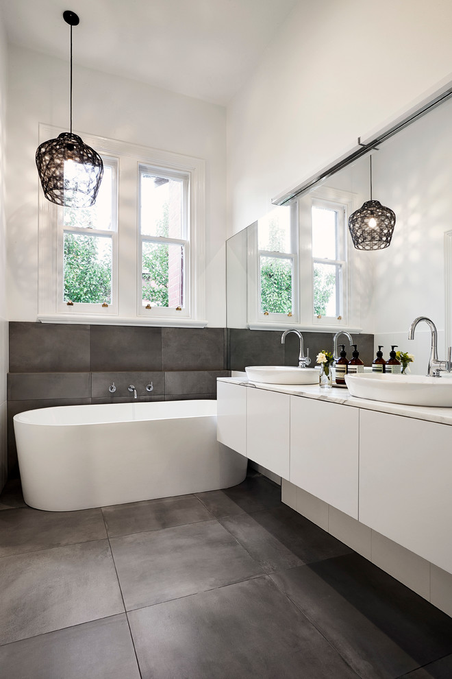 Ejemplo de cuarto de baño actual con bañera exenta y baldosas y/o azulejos grises
