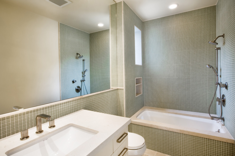 Idéer för mellanstora funkis badrum, med ett undermonterad handfat, släta luckor, vita skåp, granitbänkskiva, ett undermonterat badkar, en dusch/badkar-kombination, en toalettstol med hel cisternkåpa, grön kakel, mosaik, beige väggar och klinkergolv i keramik