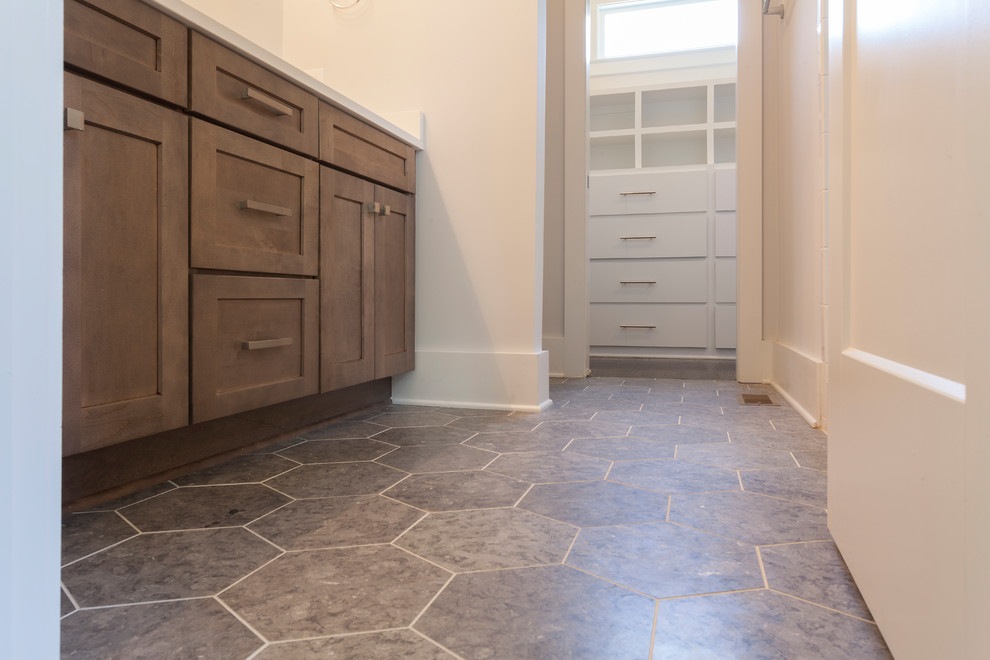 Example of a mid-sized transitional master laminate floor and gray floor bathroom design in Nashville with shaker cabinets, light wood cabinets, white walls, an undermount sink and solid surface countertops