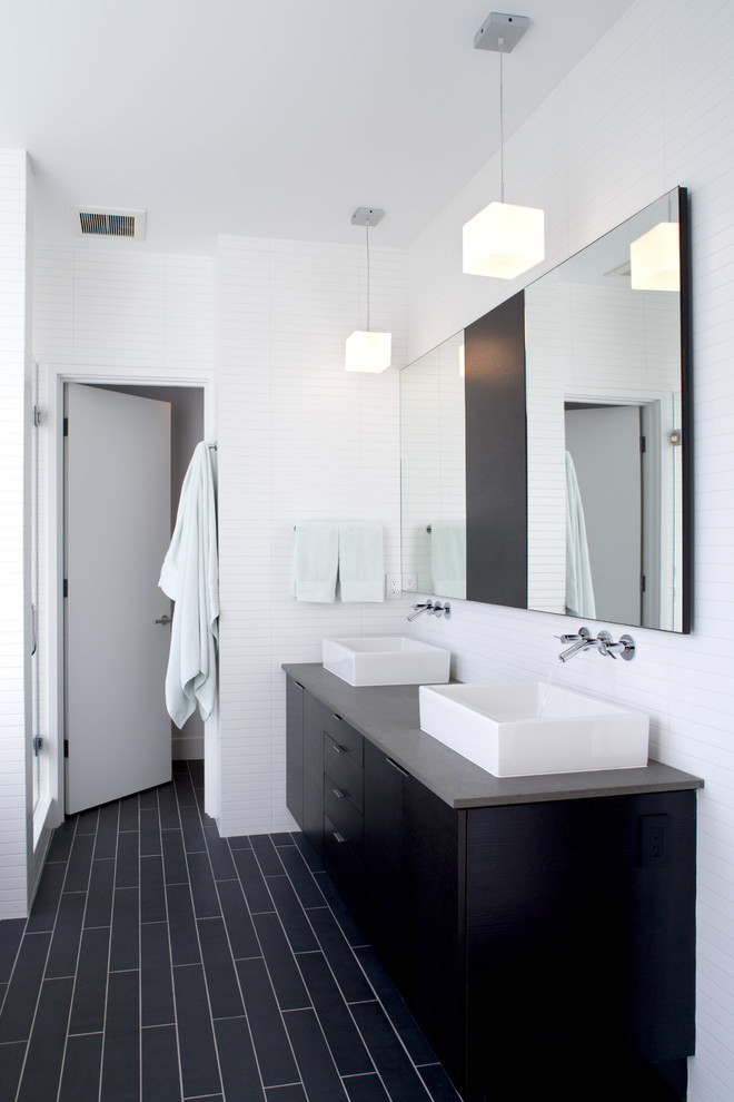 Modern inredning av ett badrum, med ett fristående handfat och svart golv