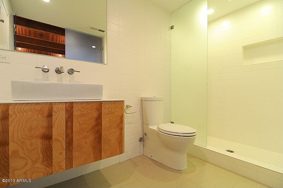 Small modern ensuite bathroom in Phoenix with flat-panel cabinets, light wood cabinets, a walk-in shower, white tiles, metro tiles, white walls, concrete flooring, grey floors and an open shower.
