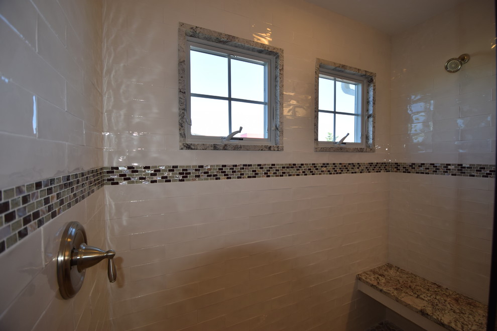 Foto på ett maritimt en-suite badrum, med luckor med upphöjd panel, skåp i mörkt trä, en kantlös dusch, svart och vit kakel, vita väggar, klinkergolv i keramik, ett undermonterad handfat och granitbänkskiva