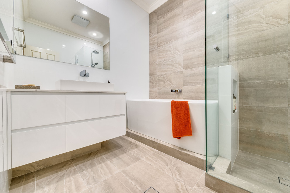 Exempel på ett litet modernt vit vitt en-suite badrum, med vita skåp, ett fristående badkar, en hörndusch, en toalettstol med hel cisternkåpa, flerfärgad kakel, porslinskakel, vita väggar, klinkergolv i porslin, ett konsol handfat, bänkskiva i akrylsten, flerfärgat golv och dusch med gångjärnsdörr