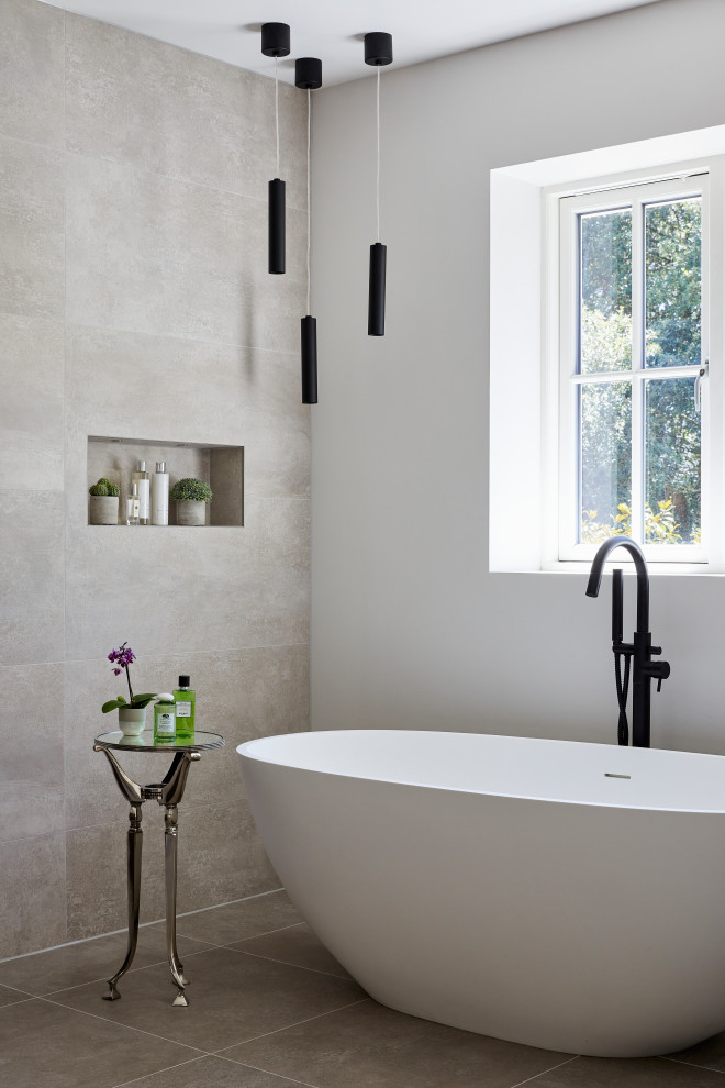 Diseño de cuarto de baño contemporáneo grande con bañera exenta, baldosas y/o azulejos grises, paredes blancas, suelo gris y hornacina
